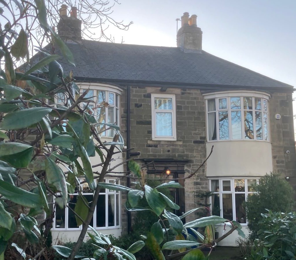Image of a double fronted Victorian built house with greenery in front - Glebe House